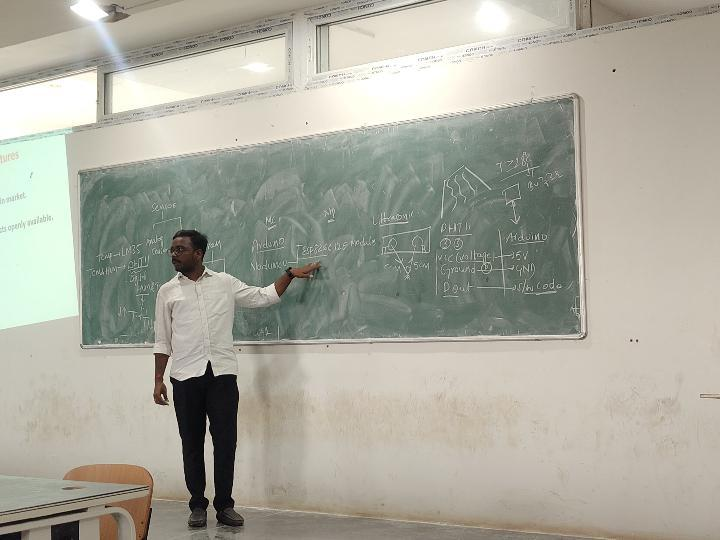 RIZIQ instructor explaining embedded systems at a classroom board
